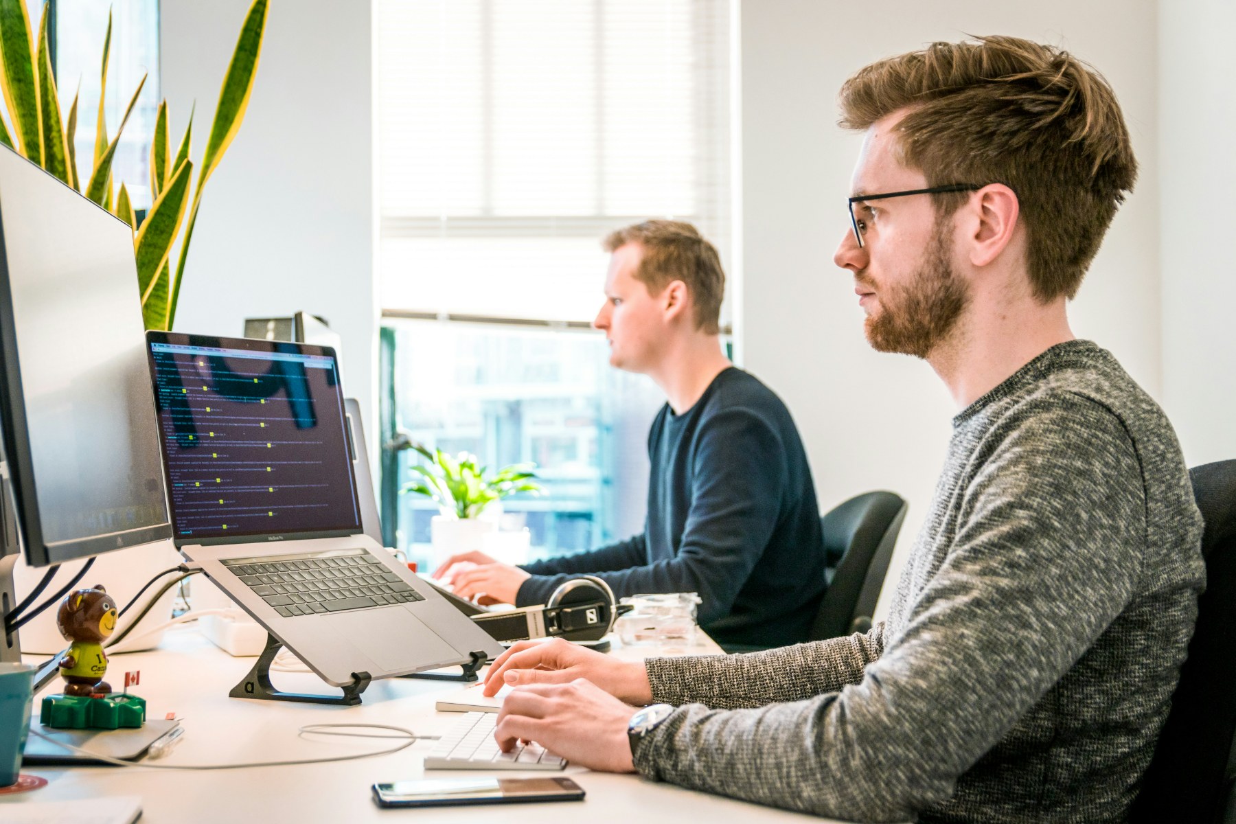 Zwei Mitarbeiter im YOU-DRIVE Support, konzentriert am Arbeitsplatz